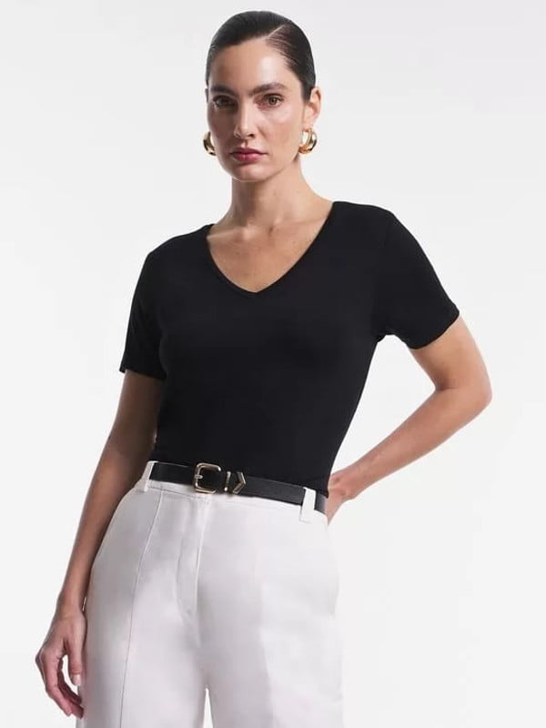 Blusas femininas para uniforme: modelo vestindo uma blusa básica em meia malha com decote V preta.