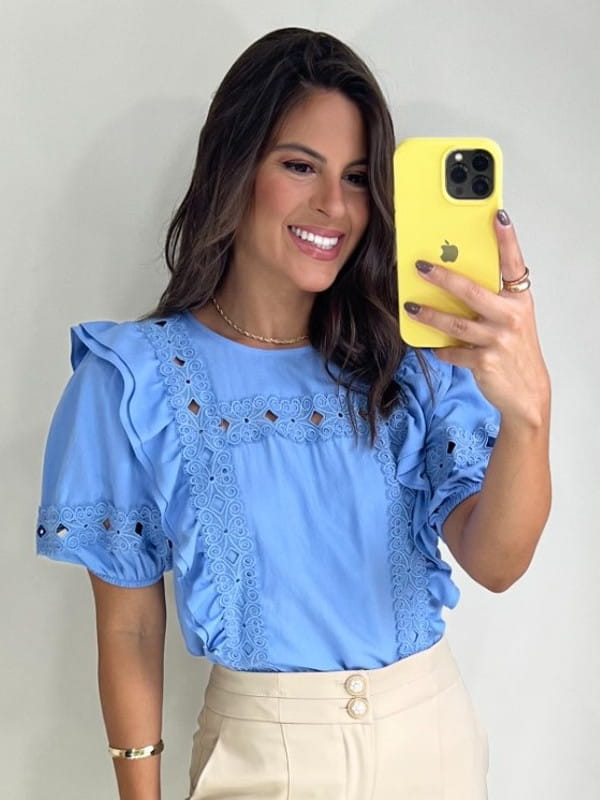 Blusa de linho feminina: modelo vestindo uma blusa de linho azul clara com renda.