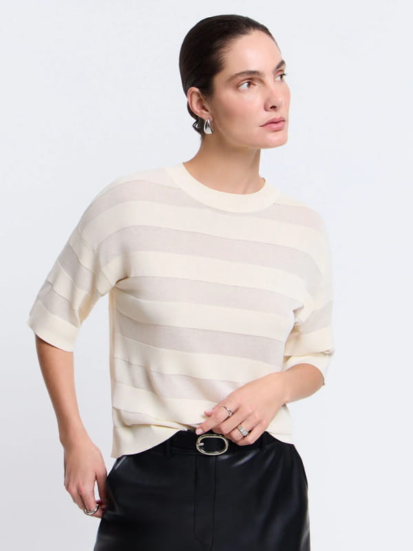 Blusa de viscose feminina: modelo vestindo uma blusa em viscose com padronagem listrada e transparências off white.