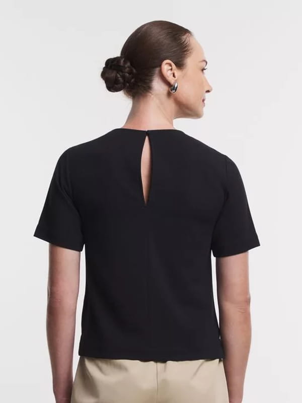 Blusa feminina de crepe: modelo vestindo uma blusa em crepe com detalhe de correntinha na gola - costas.