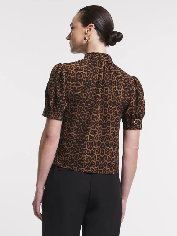 Blusa feminina de crepe: modelo vestindo uma blusa de crepe com golinha alta animal print costas.