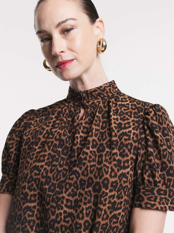 Blusa feminina de crepe: modelo vestindo uma blusa de crepe com golinha alta animal print detalhes.