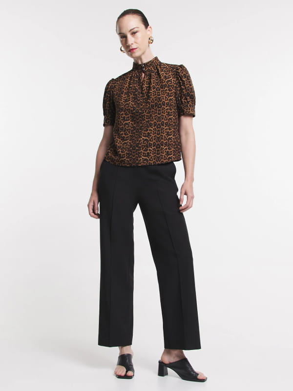 Blusa feminina de crepe: modelo vestindo uma blusa de crepe com golinha alta animal print look.