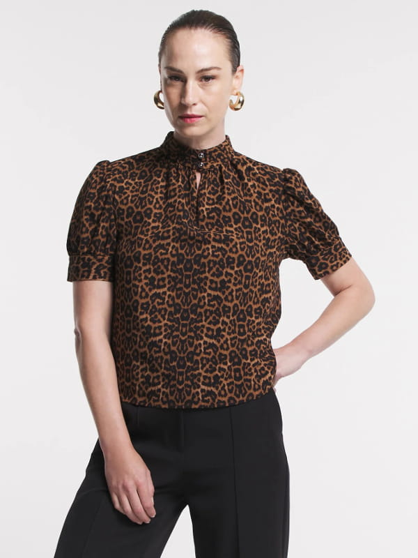 Blusa feminina de crepe: modelo vestindo uma blusa de crepe com golinha alta animal print.