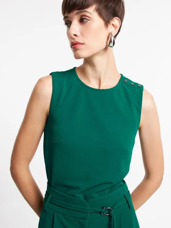 Blusa feminina de crepe: modelo vestindo uma blusa de crepe sem manga com botões nos ombros verde - estilo.