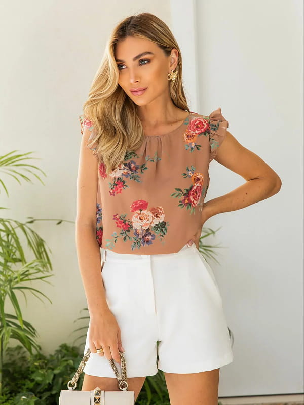 Blusa floral feminina: modelo vestindo uma blusa floral marrom com short alfaiataria branco.