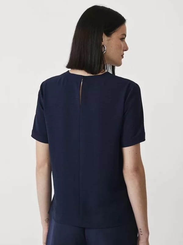 Blusa social feminina: modelo vestindo uma blusa com abertura nas costas e detalhes pespontados - costas.