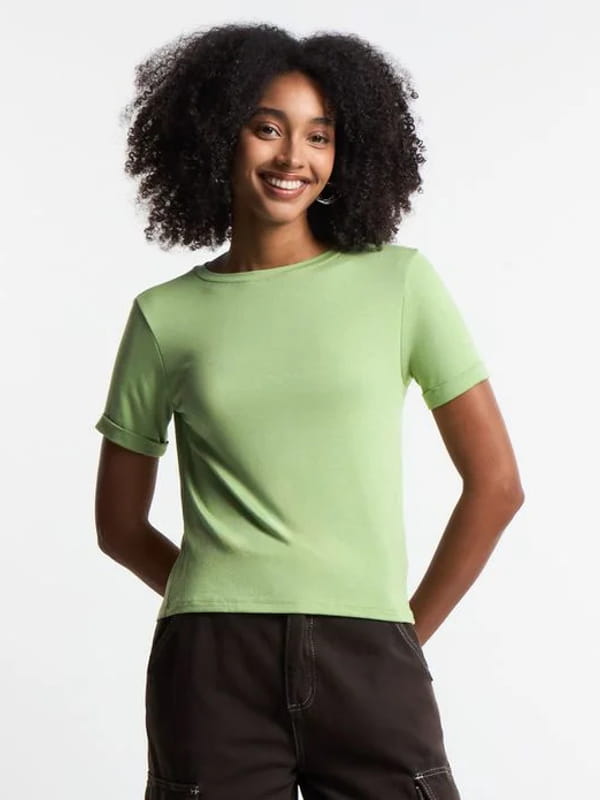 Expressões e gírias de moda: modelo vestindo uma blusa em viscose com manga dobrada verde claro.