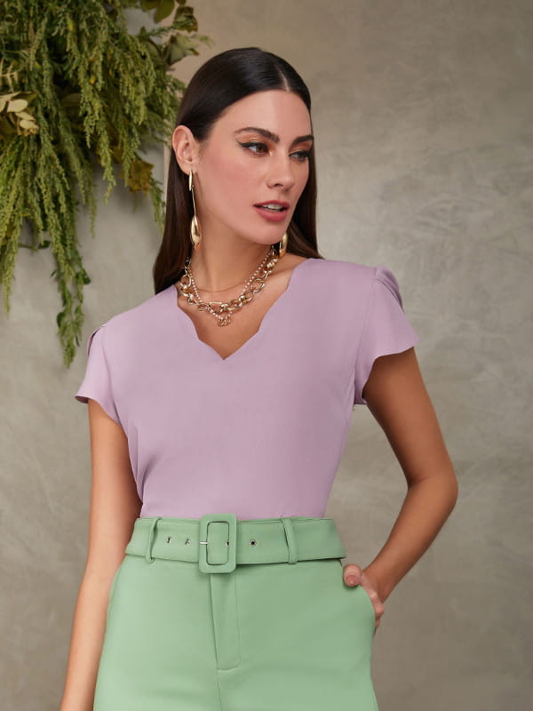 Blusas femininas para trabalhar: modelo vestindo uma blusa de crepe lilás com decote nuvem.