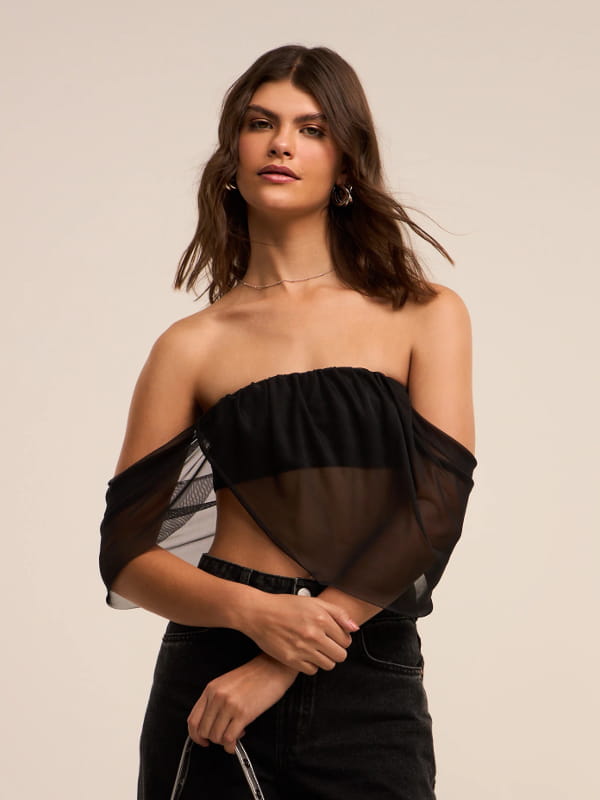 Looks com blusa tomara que caia: modelo vestindo uma blusa tomara que caia em tule preta.