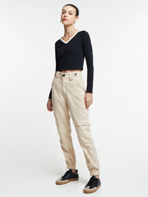 Looks com calça cargo feminina: modelo vestindo uma calça cargo feminina jogger cintura alta bege.