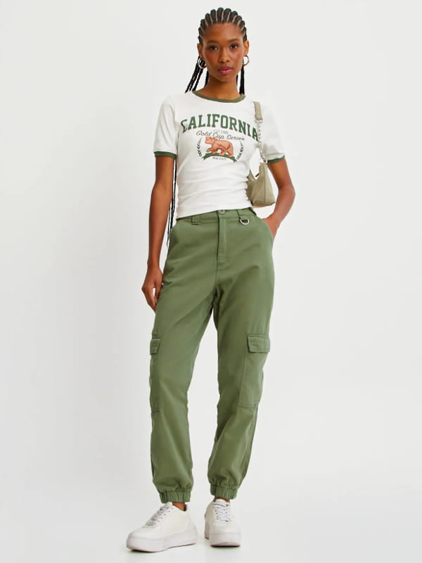 Looks com calça cargo feminina: modelo vestindo uma calça cargo feminina jogger cintura alta verde militar.