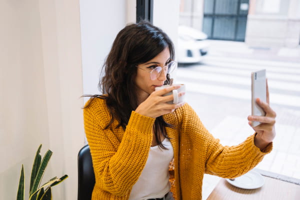 Cardigans femininos: modelo vestindo um cardigan e tomando um café.