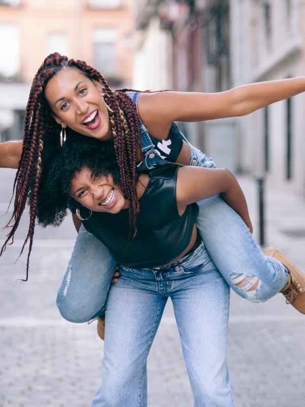 Como usar calça jeans: amiga montando cavalinho na outra e as duas usando calça jeans.