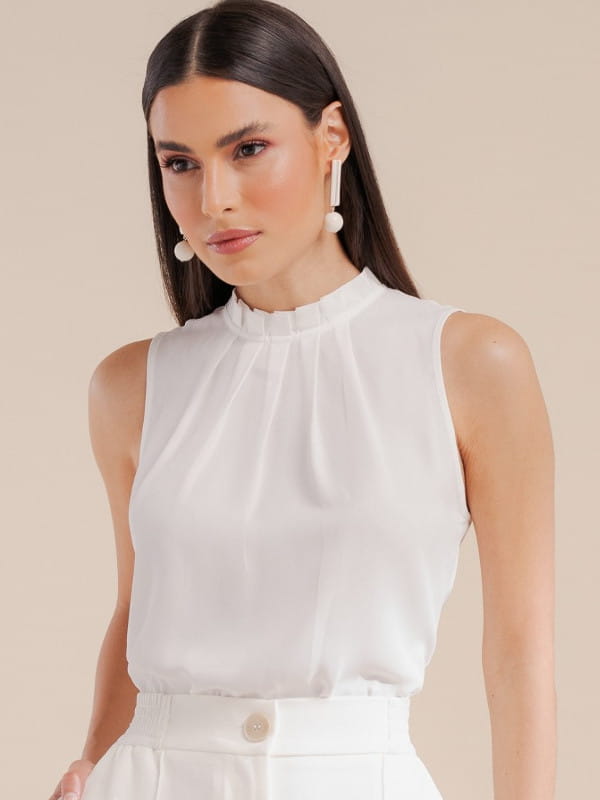 Cores que combinam com branco: modelo vestindo uma regata de crepe básica com pregas cor off white.