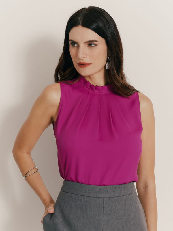 Cores que combinam com fucsia: modelo vestindo uma blusa de crepe fucsia com pregas na gola.