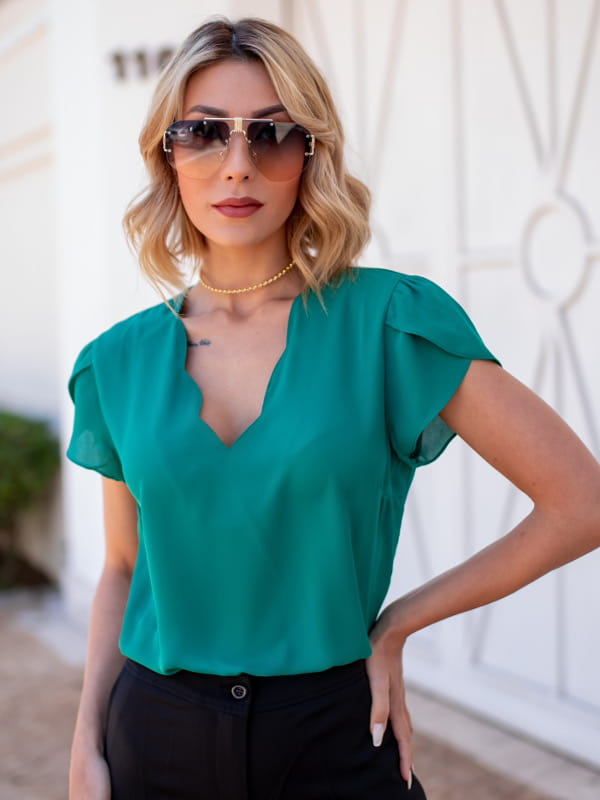 Cores que combinam com verde: modelo vestindo blusa de crepe decote nuvem verde floresta.