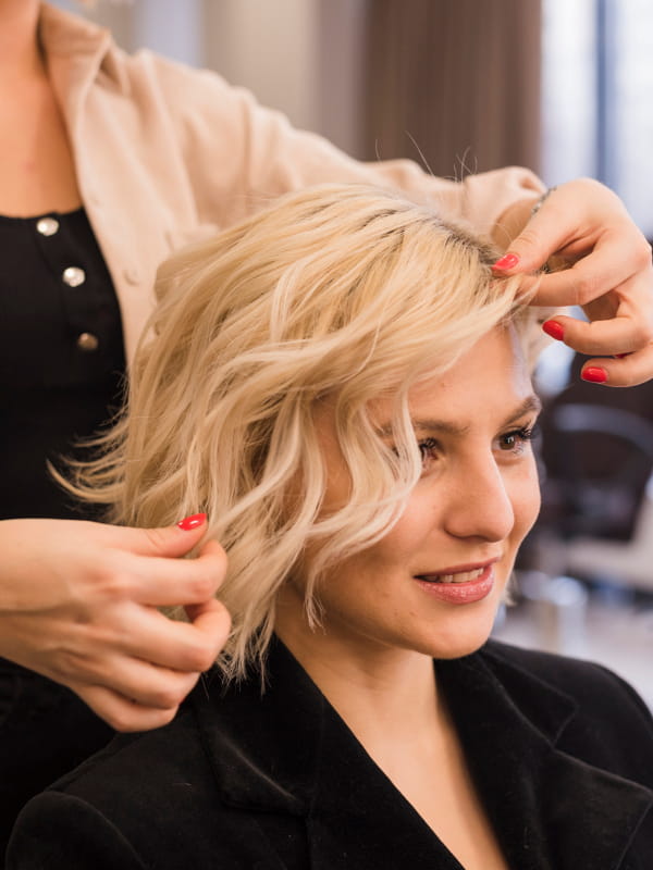 Cringe: entenda este termo da moda: mulher loira cortando o cabelo.