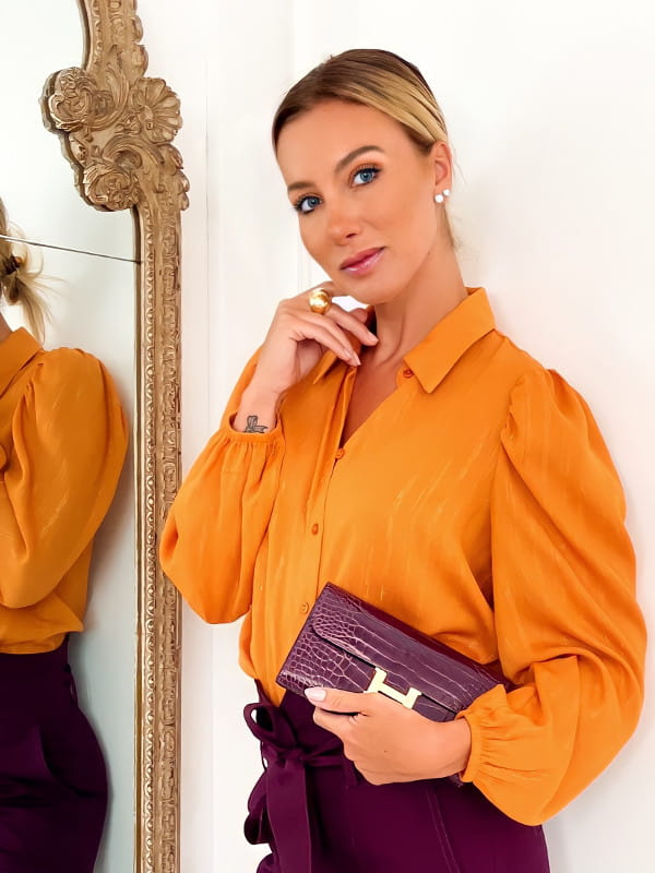 Look com camisa social feminina: modelo usando uma camisa social laranja.