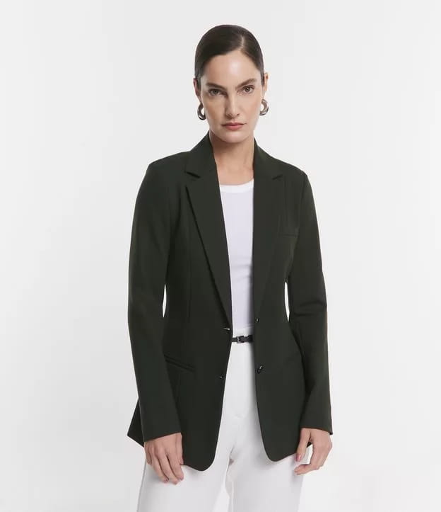 Look social feminino: modelo vestindo um blazer alongado ponto roma com bolsos embutidos verde musgo.