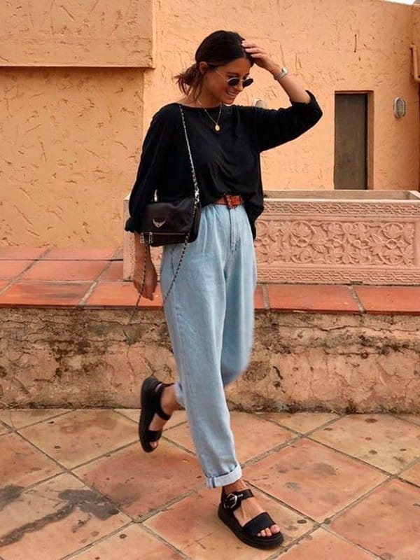 Looks com calça slouchy: modelo usando uma calça slouchy jeans com blusa preta.