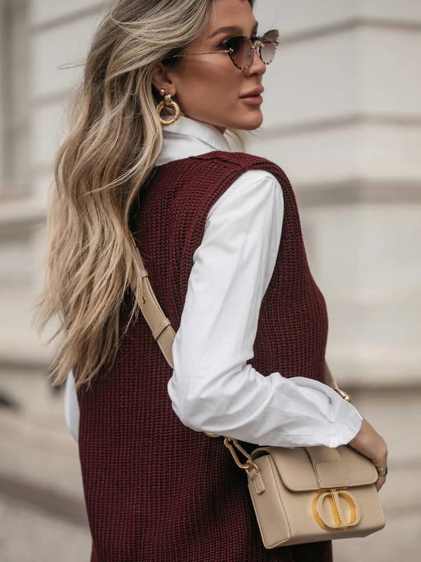 Looks para arrasar com a terceira peça: modelo vestindo um colete de tricot marsala e calça jeans - costas.