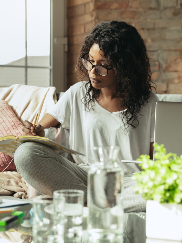 Looks para ficar em casa sem perder o estilo: mulher trabalhando no sofá com seu notebook.