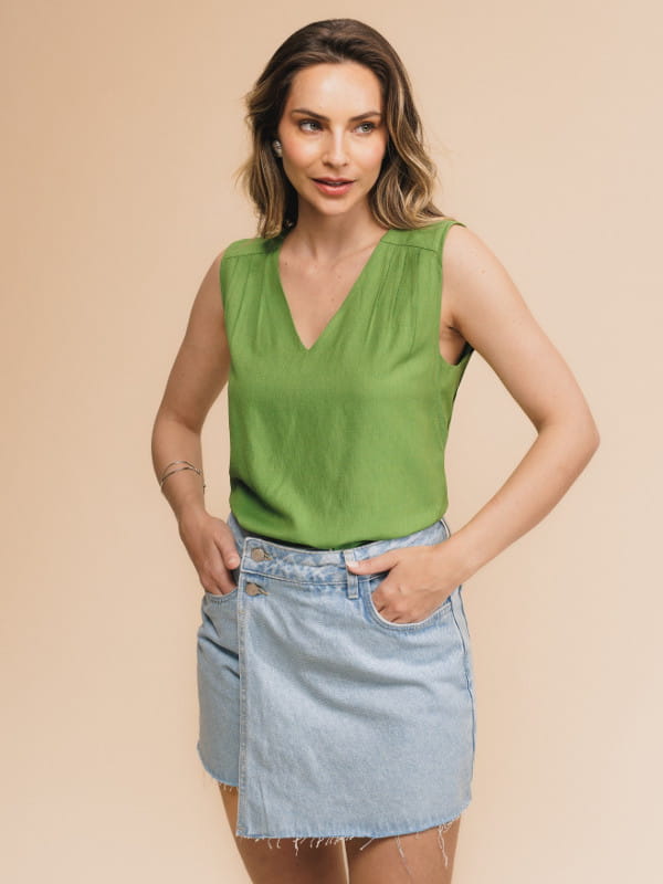 Regata de viscose feminina: modelo vestindo uma regata com decote V na cor verde com uma calça jeans.