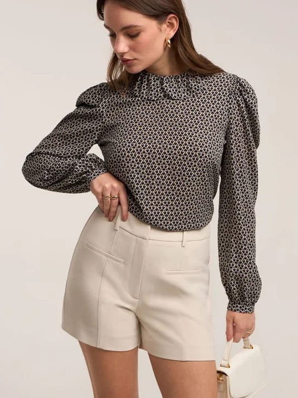 Roupas femininas para trabalhar: modelo vestindo um short alfaiatada em crepe com bolso fake bege.