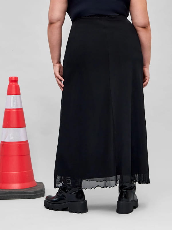 Coturno com saia midi: modelo usando uma saia midi em tule com frufru na barra curve plus size preta - costas.